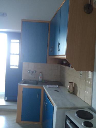 a kitchen with blue cabinets and a sink at Windmill Villas in Artemonas