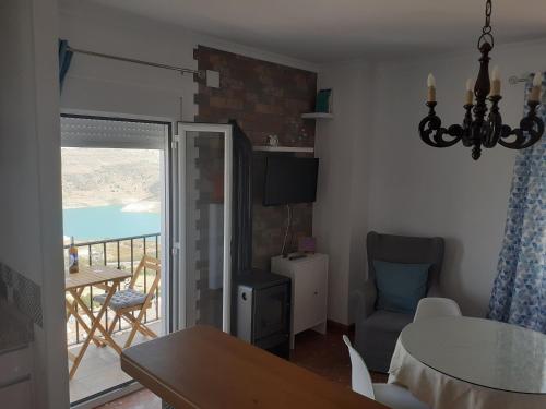 a living room with a table and a view of the ocean at Casa Rural Plaza Zahara Buenas Vistas in Zahara de la Sierra