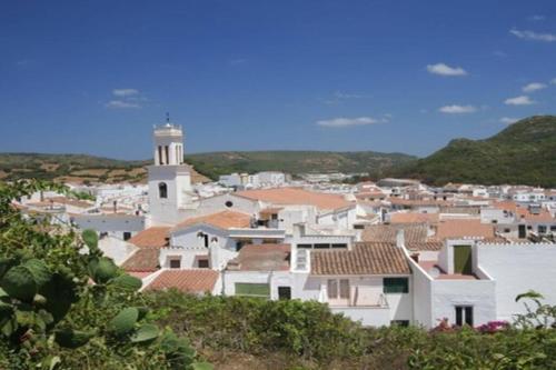 un pueblo con un faro a lo lejos en Casa en Ferreries, en Ferreries
