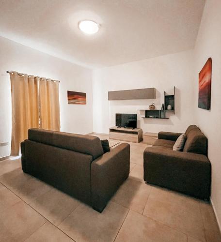 a living room with two couches and a fireplace at Central Modern Apartment in Il-Gżira