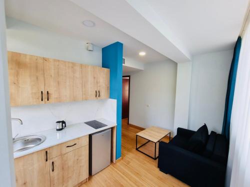 a kitchen with a sink and a couch in a room at Graphica Black Sea in Shekhvetili