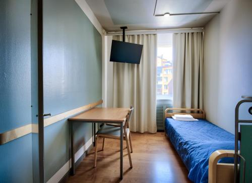 a bedroom with a bed and a desk and a table at Eurohostel in Helsinki