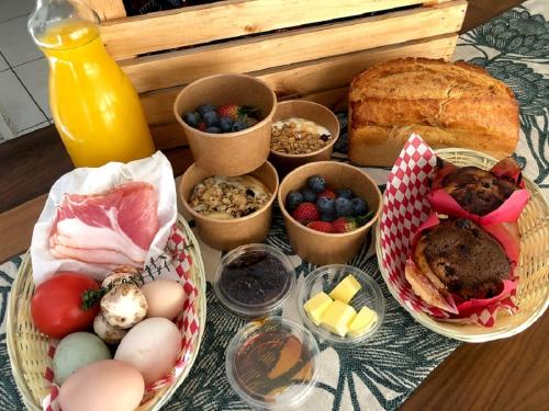 a table with plates of food and bread and bowls of food at High Season Farm Luxury Cottages in Hermanus