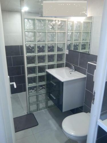 une salle de bain avec un lavabo et des toilettes dans l'établissement l'essentiel, à Ault