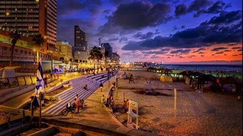 a city street at night with people on the beach at Dizengoff Avenue Boutique Hotel in Tel Aviv