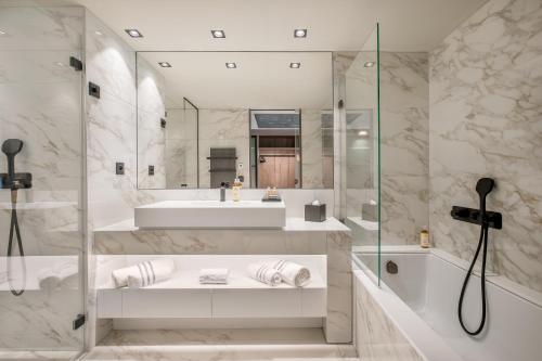 a bathroom with a tub and a sink and a shower at Rivage Hôtel & Spa Annecy in Annecy