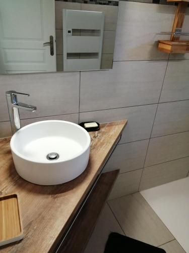 une salle de bain avec un lavabo blanc sur un comptoir en bois dans l'établissement Maison à la campagne, à Lyaud