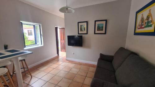 a living room with a couch and a table at Casa da Avó Duca in Machico