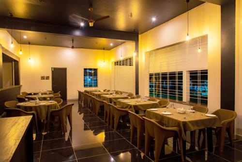 a restaurant with tables and chairs in a room at Mastiff Select Shreeyog Resort in Dandeli