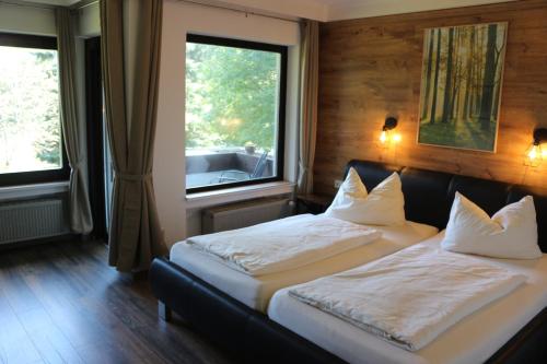 um quarto com 2 camas e uma grande janela em Waldgasthaus am Schwarzenbruch em Allenbach