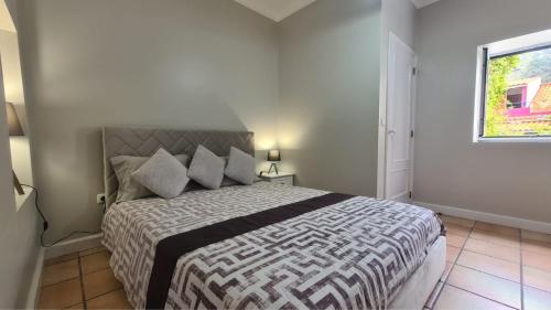 a bedroom with a large bed in a room at Casa da Avó Duca in Machico