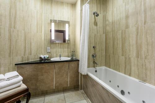 a bathroom with a bath tub and a sink at Doxford Hall Hotel And Spa in Alnwick