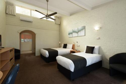 Habitación de hotel con 2 camas y sofá en Barclay Motor Inn en Devonport