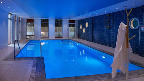 a large swimming pool with blue lighting in a building at Domitys Les Houblons in Brest
