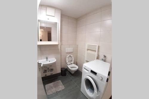 a white bathroom with a toilet and a sink at LEA Apartments Luxus-3-Raum-Wohnung mit Tiefgarage in Leipzig