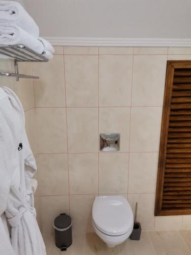 a bathroom with a white toilet and towels at Kavaler inn hotel in Kuty
