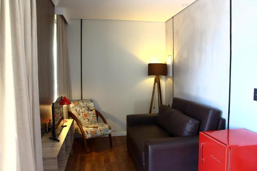 a living room with a couch and a chair at Hotel Fazenda Terra dos Sonhos in Bueno Brandão