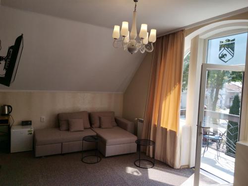 a living room with a couch and a window at Kavaler inn hotel in Kuty
