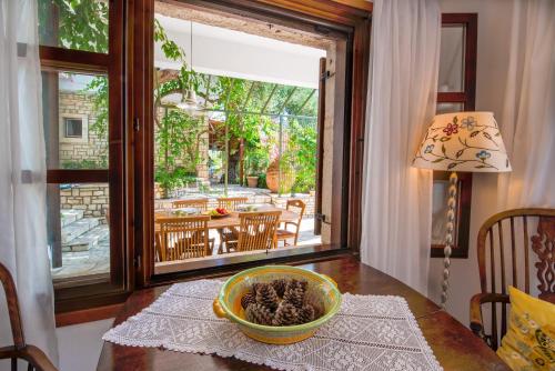 a dining room table with a bowl of pine cones on it at Bougainvillea in Gaios