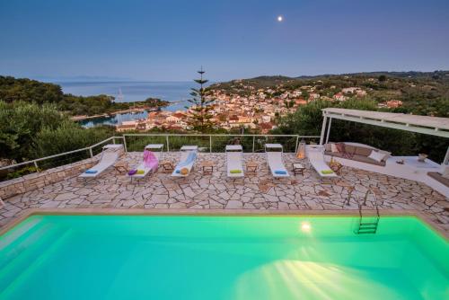 a swimming pool with chairs and a view of the ocean at Bougainvillea in Gaios