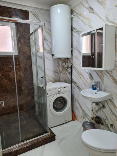 Un baño con lavadora y lavabo. en Ivana's apartment, en Bitola