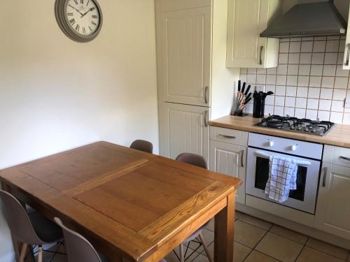 cocina con mesa y reloj en la pared en Springfield en Oakham