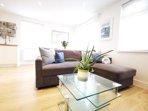 a living room with a couch and a glass table at Apartment in the heart of East Wittering Village in Chichester