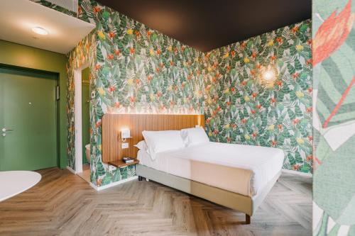 A bed or beds in a room at Collini Rooms Hotel