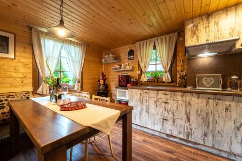 una cucina con tavolo in legno in una camera di SOVIA WELLNESS CHATA s jacuzzi kaďou a saunou, Čingov a Smižany
