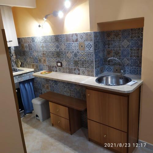 a kitchen with a sink and blue tiles at STONE HOUSE e Casa Vacanze Zia Rosina in Montemaggiore Belsito