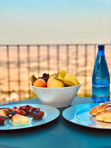 a table with two plates of food and a bowl of fruit at RELAIS SAN MARCO LUXURY GUEST HOUSE in Volturino
