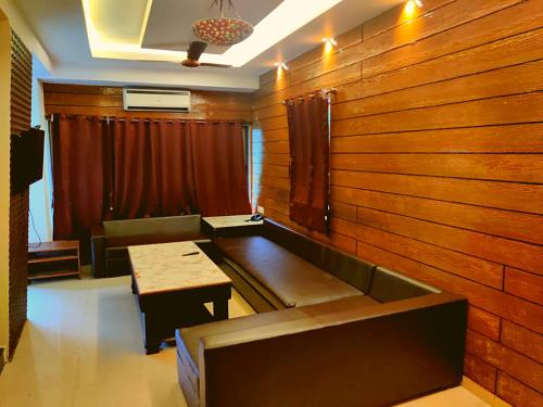 a room with a wooden wall with a bench and a table at Hill Forest Resort in Lonavala