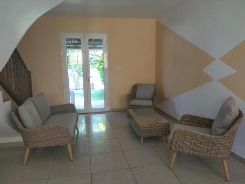 - un salon avec deux chaises et une table dans l'établissement Petite maison à 12mn du bassin de Manapany, à Saint-Joseph