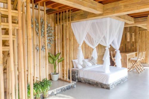 a bedroom with a bed in a room with wooden walls at Camaya Bali - Magical Bamboo Houses in Selat