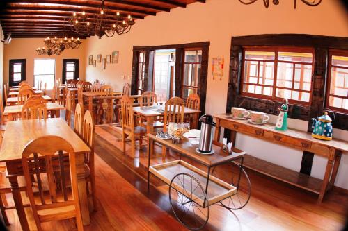 uma sala de jantar com mesas e cadeiras de madeira em Pousada Toque Mineiro em Tiradentes