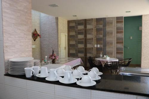 uma cozinha com copos e pratos brancos num balcão em Pousada Marinah em São José da Coroa Grande