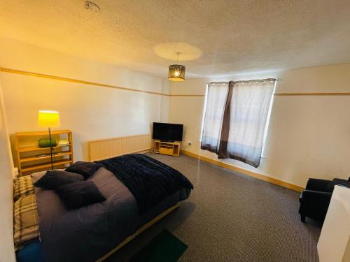 a bedroom with a bed and a television in it at Shous Guest house in Bristol