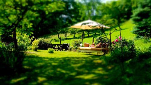 a garden with a couch and an umbrella in the grass at Willa Marysin in Maków Podhalański