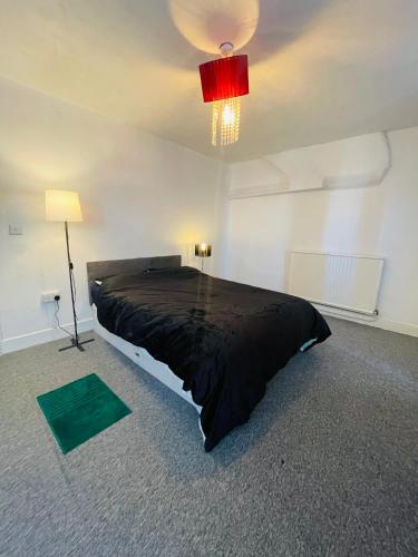 a bedroom with a large bed and a red light at Shouss guest house in Bristol