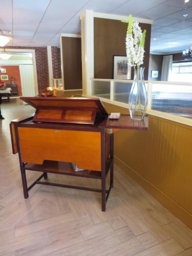 a desk with a vase of flowers on top of it at Wingate by Wyndham Elkins in Elkins