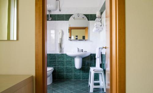 a bathroom with a sink and a toilet and a mirror at Hotel Rosa Del Tirreno in Quercianella