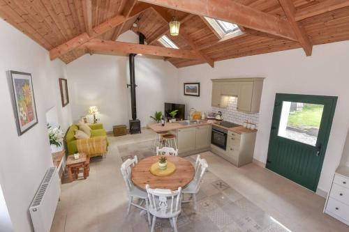a kitchen and living room with a wooden table and chairs at Quarterland's Barn in Killinchy