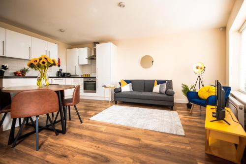 een keuken en een woonkamer met een tafel en stoelen bij Emerald Court Executive Watford Central Apartment by PAY AS U STAY in Watford