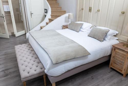 a bed with white sheets and pillows in a bedroom at La Regalido in Fontvieille