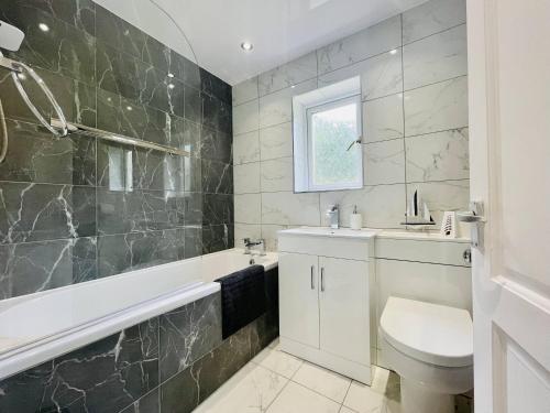 a bathroom with a sink and a toilet and a tub at Central Hamilton House in Hamilton