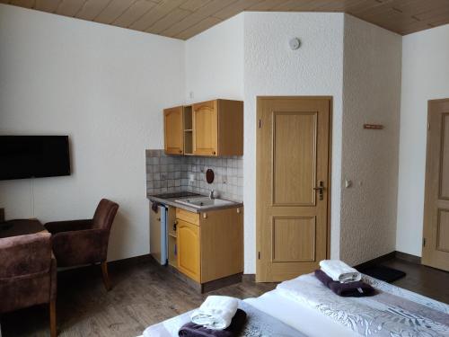 a room with a bed and a kitchen with a sink at Haus Savina in Weimar