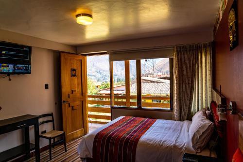 a bedroom with a bed and a large window at Hotel Tierra Inka Sacred Valley in Ollantaytambo