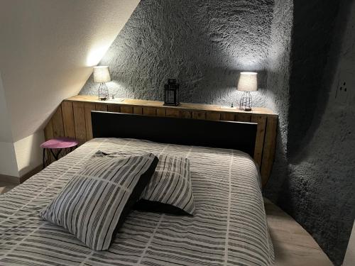 Una cama con dos lámparas encima. en Gîte Les lavandières, en Colmar