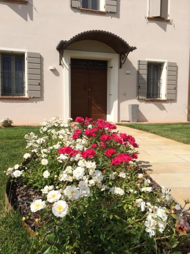 a bed of flowers in front of a house at B&B Arcadia in Gualtieri