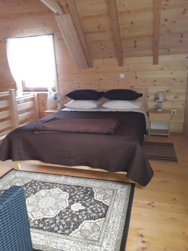 a bedroom with a large bed in a wooden room at Planinske kuce Good Night in Donji Babin Potok